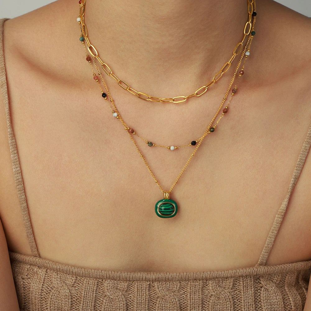Collier pendentif malachite porté par une femme avec 2 autres colliers en acier inoxydable doré