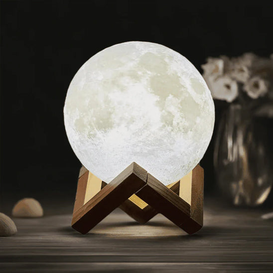 lampe de chevet en forme de lune lumière blanche dans le noir socle en bois sur table de nuit vase fleurs