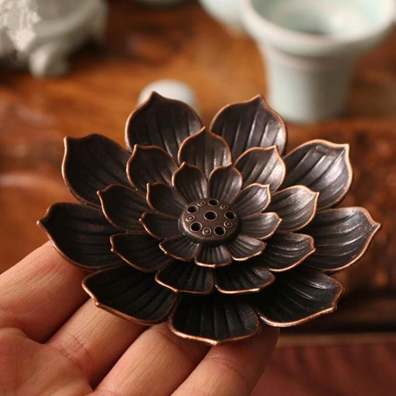 porte encens fleur de lotus marron 6 trous au centre pour bĂątons d'encens dans la main d'une personne