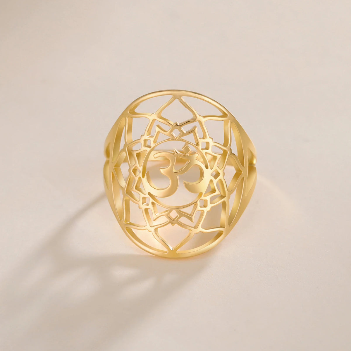 Bague chakra Couronne dorée, vue de face avec motif géométrique ajouré et symbole Om.