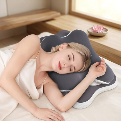 Femme blonde allongée sur le côté, la tête posée sur le Butterfly design oreiller gris et blanc.