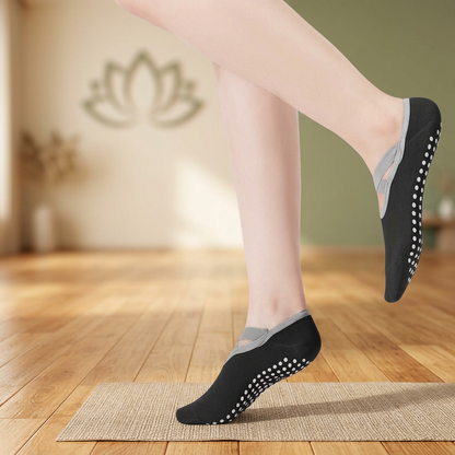 Chaussettes de yoga noires en mouvement, avec un pied au sol et l’autre relevé.