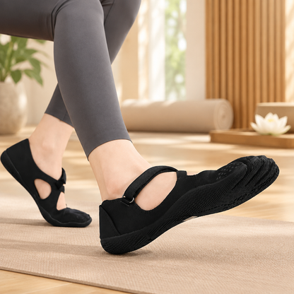 Chaussons de yoga noirs antidérapants portés dans un espace yoga zen 