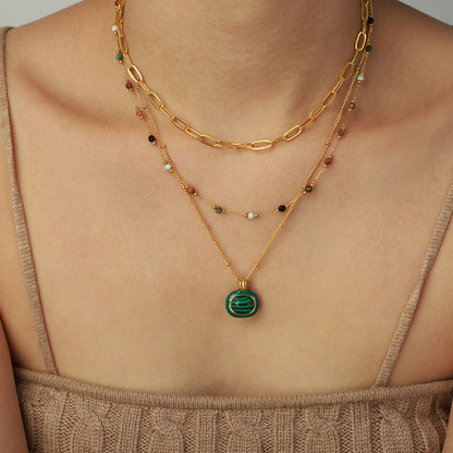 Collier pendentif malachite porté par une femme avec 2 autres colliers en acier inoxydable doré