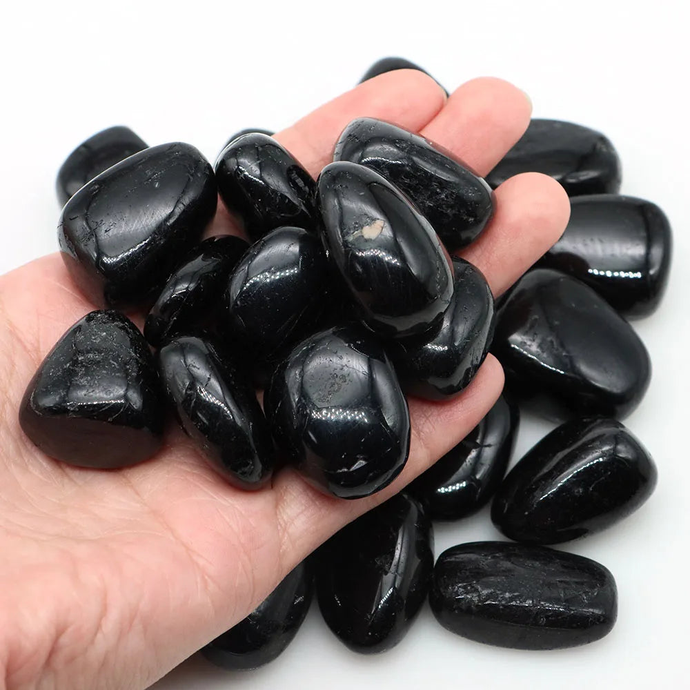 Tourmaline noire pierres naturelles roulées en vrac dans une main - collection lithothérapie
