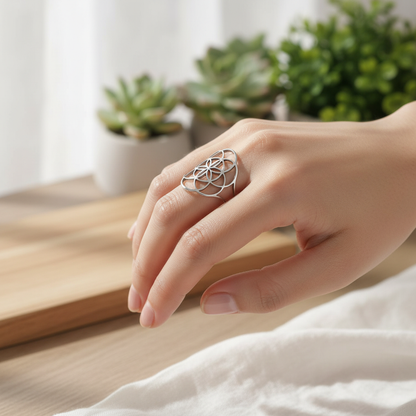 Bague femme fleur de vie argentée portée au doigt fond zen