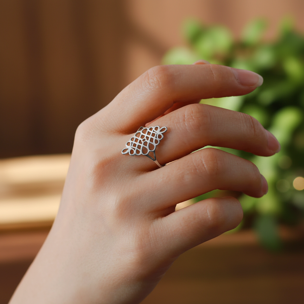 Bague spirituelle géométrique argentée portée au doigt fond zen