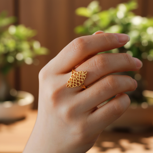 Bague spirituelle géométrique dorée portée au doigt fond zen