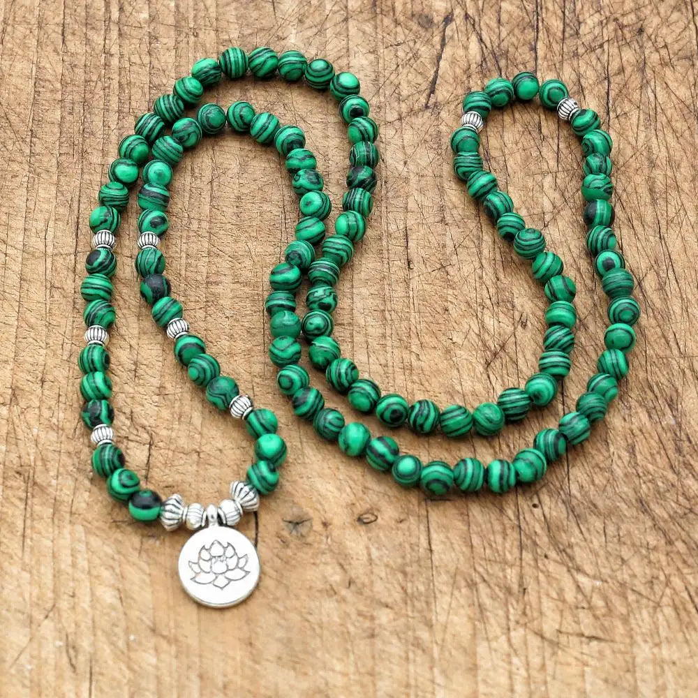 Bracelet perle malachite 108 perles déroulé sur bois – mala lotus méditation