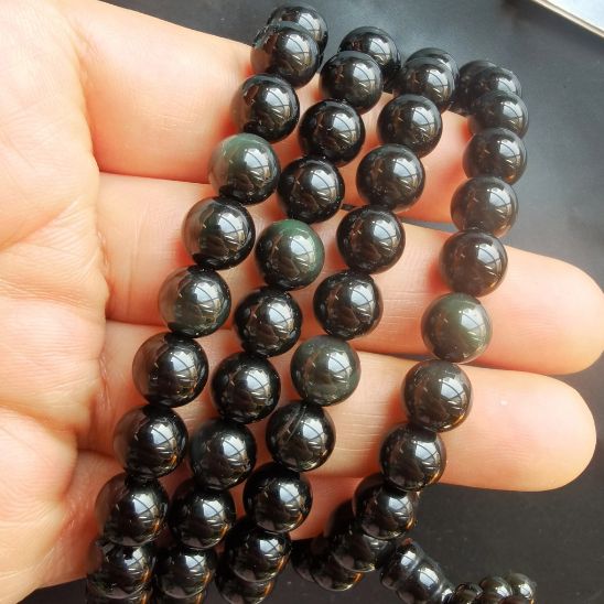 collier perles noires brillantes main