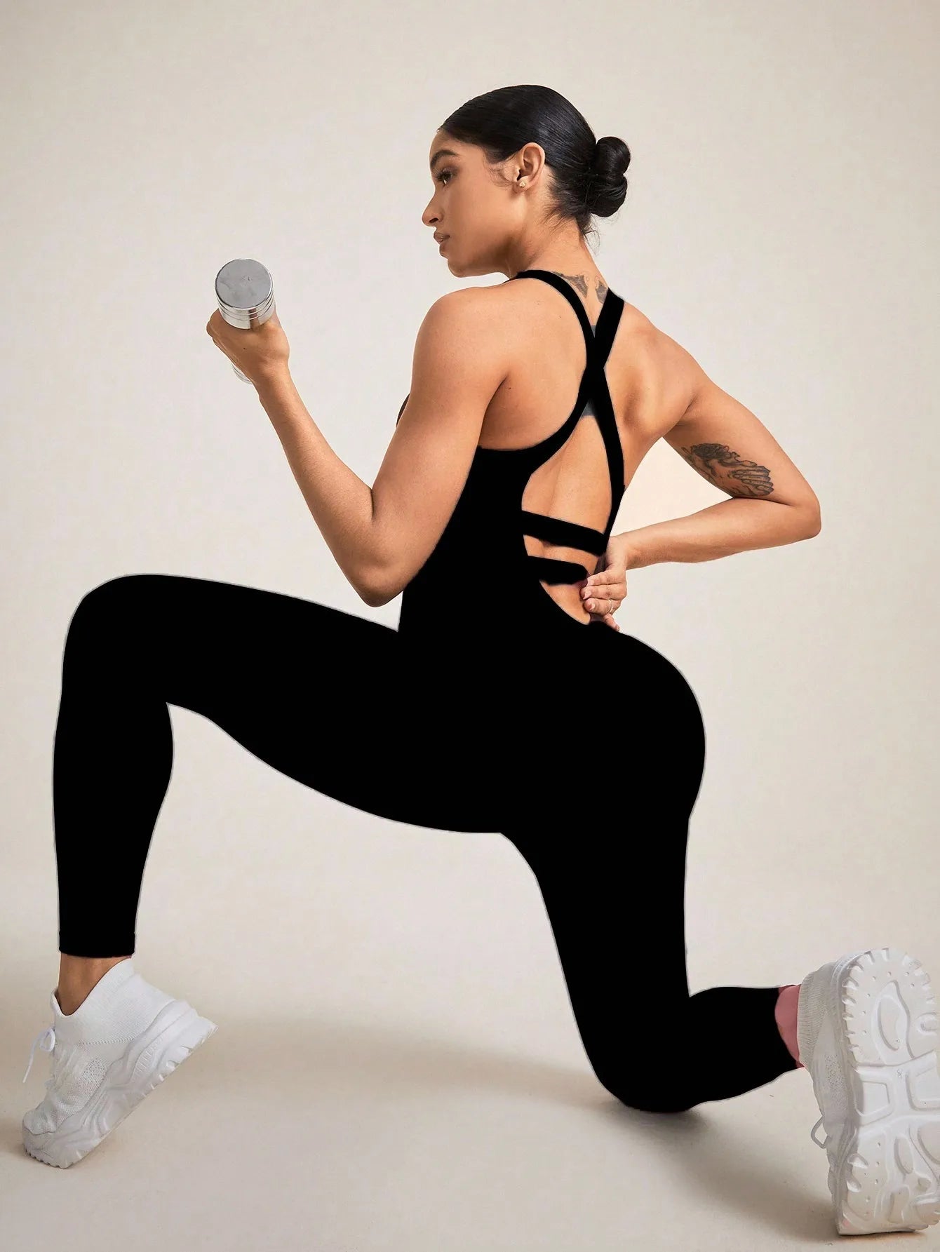 Combinaison femme sport noire confort ventre plat portée par une brune liberté de mouvement fitness yoga