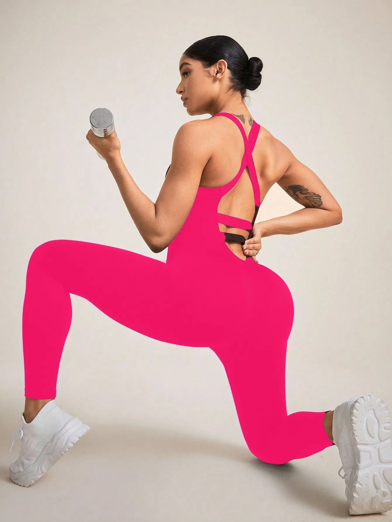 Combinaison femme sport rose fuschia confort ventre plat portée par une brune liberté de mouvement fitness yoga