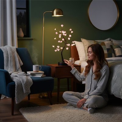 Lampe de chevet design arbre fleuri table de nuit femme position de yoga au pied de son lit