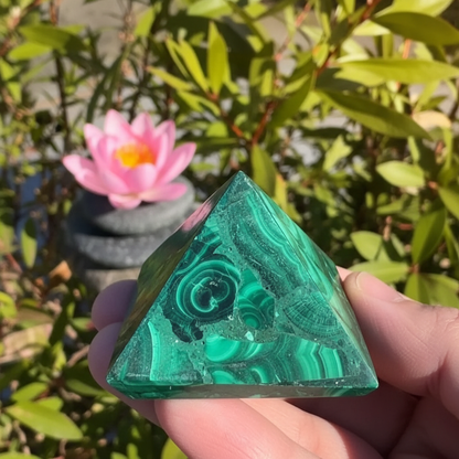 Pyramide malachite fond ensoleillé jardin lumineux – pierre naturelle énergie positive