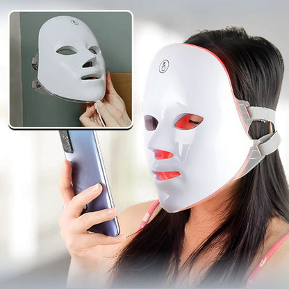masque led visage femme séance de luminothérapie regarde son smartphone