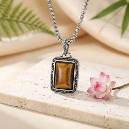 pendentif oeil de tigre homme avec monture argentée sur pierre claire dans un décor zen fleuri
