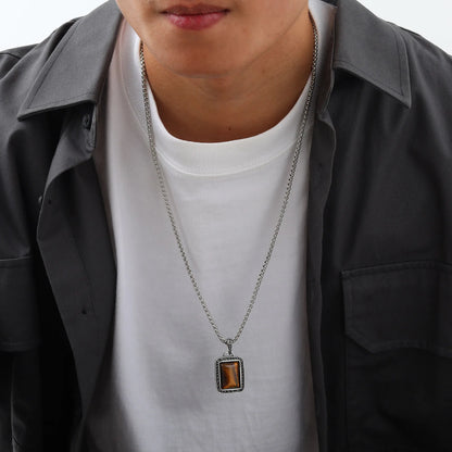 pendentif oeil de tigre homme porté sur un t-shirt blanc sous une surchemise sombre ouverte