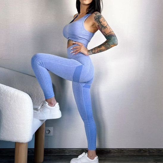 Tenue yoga brassière legging bleu extensible porté par une femme baskets blanches